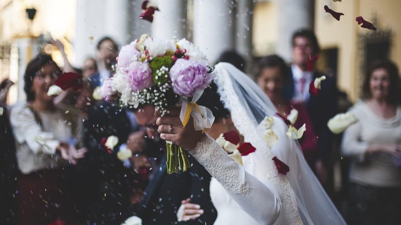 Photo of wedding bouquet held by bride with flowers falling around